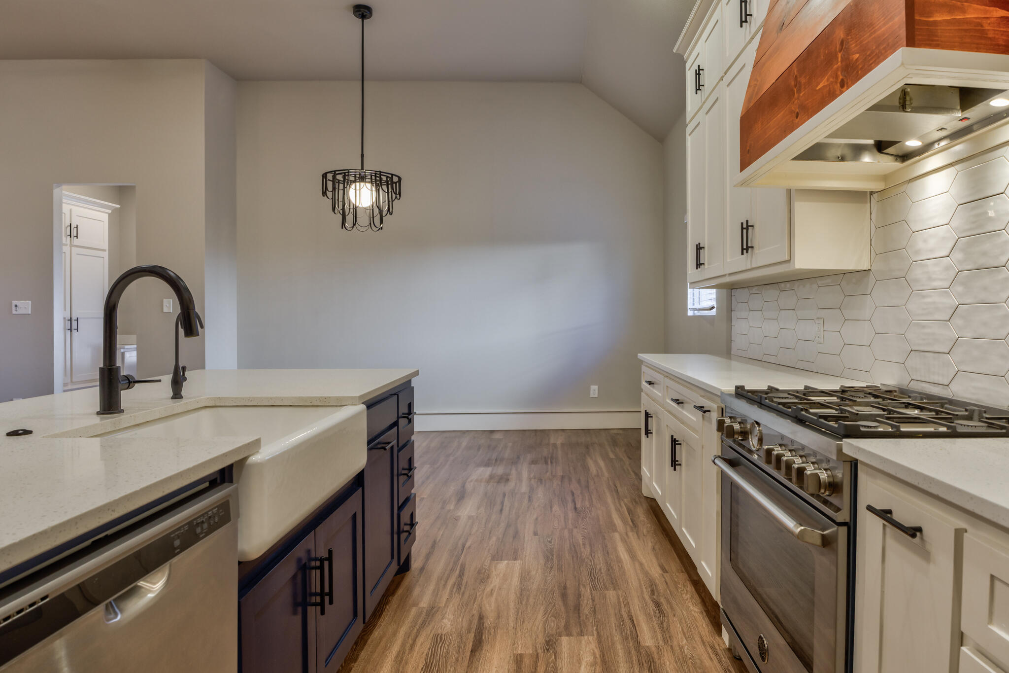 5303 110th Street Lubbock, TX 79424 - Photo 23 of 54 a kitchen with stainless steel appliances a sink a stove and a wooden floors