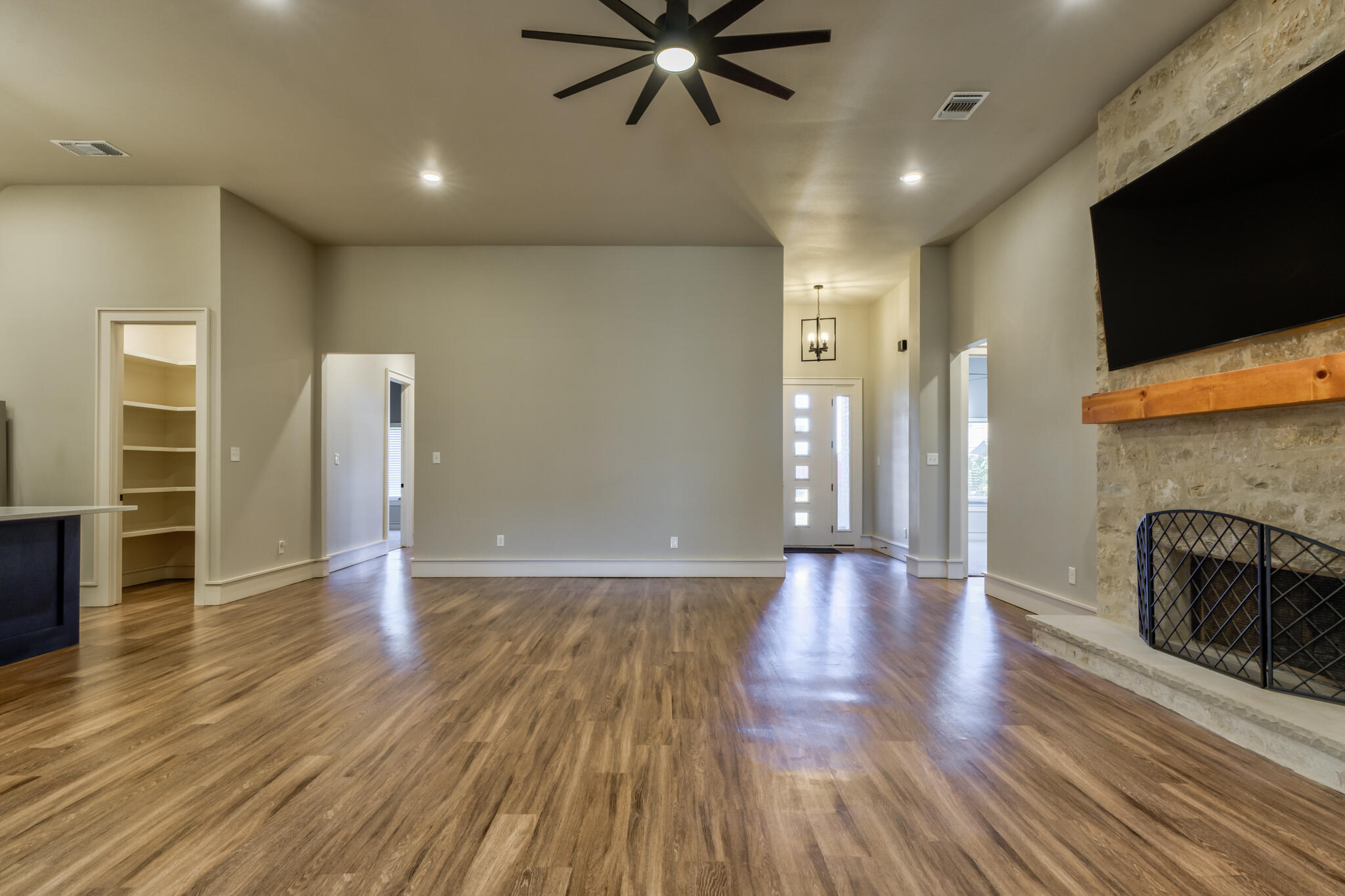 5303 110th Street Lubbock, TX 79424 - Photo 10 of 54 a view of an empty room with wooden floor and a fireplace