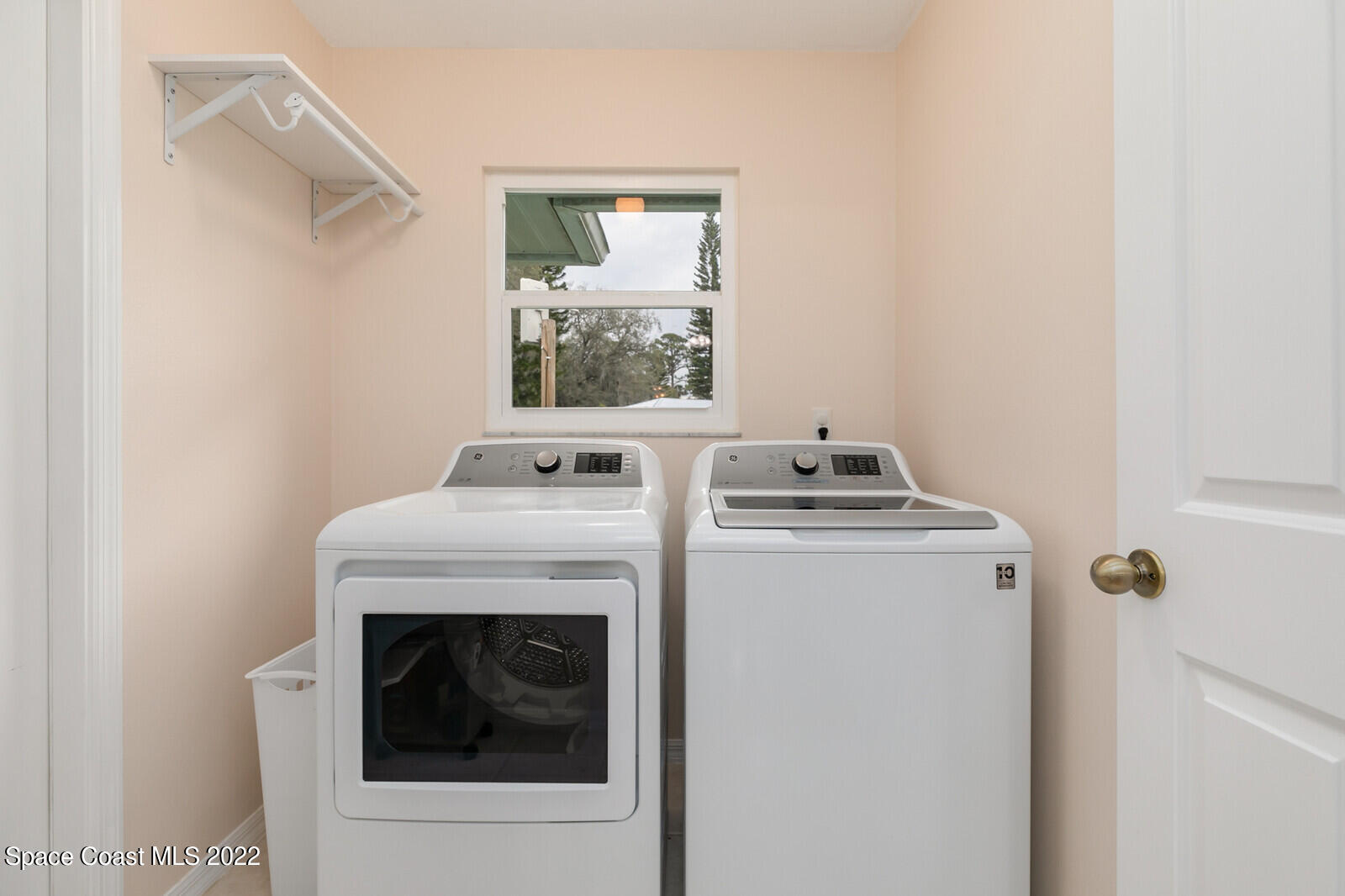 4885 Doreen Road Cocoa, FL 32927 - Photo 17 of 21 a view of washer and dryer with kitchen in the background
