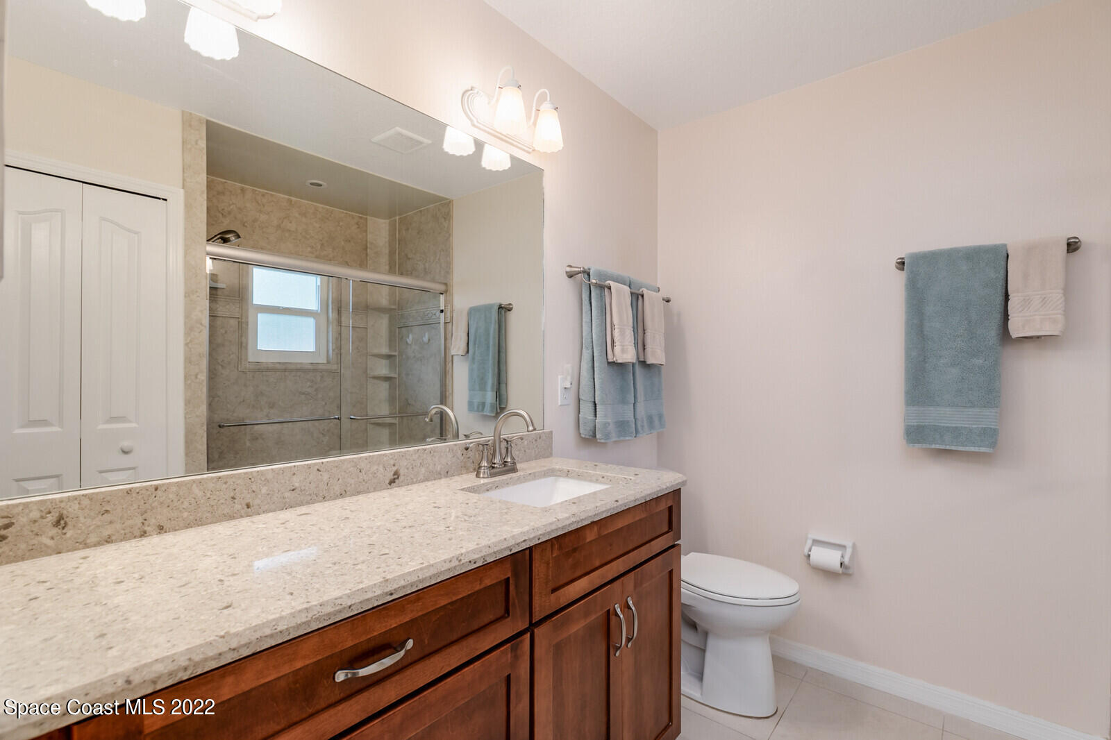 4885 Doreen Road Cocoa, FL 32927 - Photo 9 of 21 a bathroom with a granite countertop sink a toilet and mirror