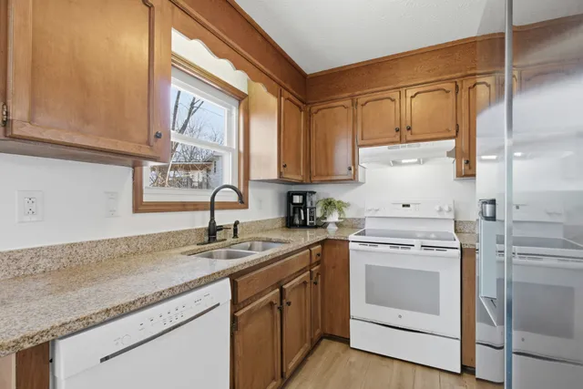 a kitchen with granite countertop a sink stainless steel appliances and cabinets