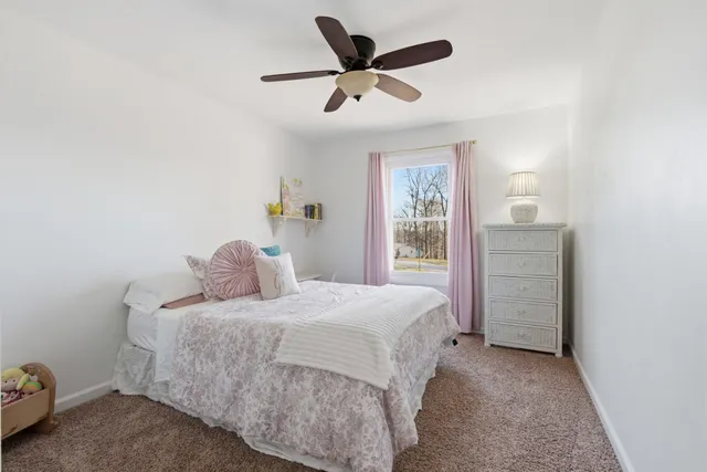 a bedroom with a bed and a ceiling fan