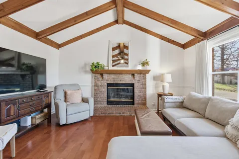 a living room with furniture a flat screen tv and a fireplace