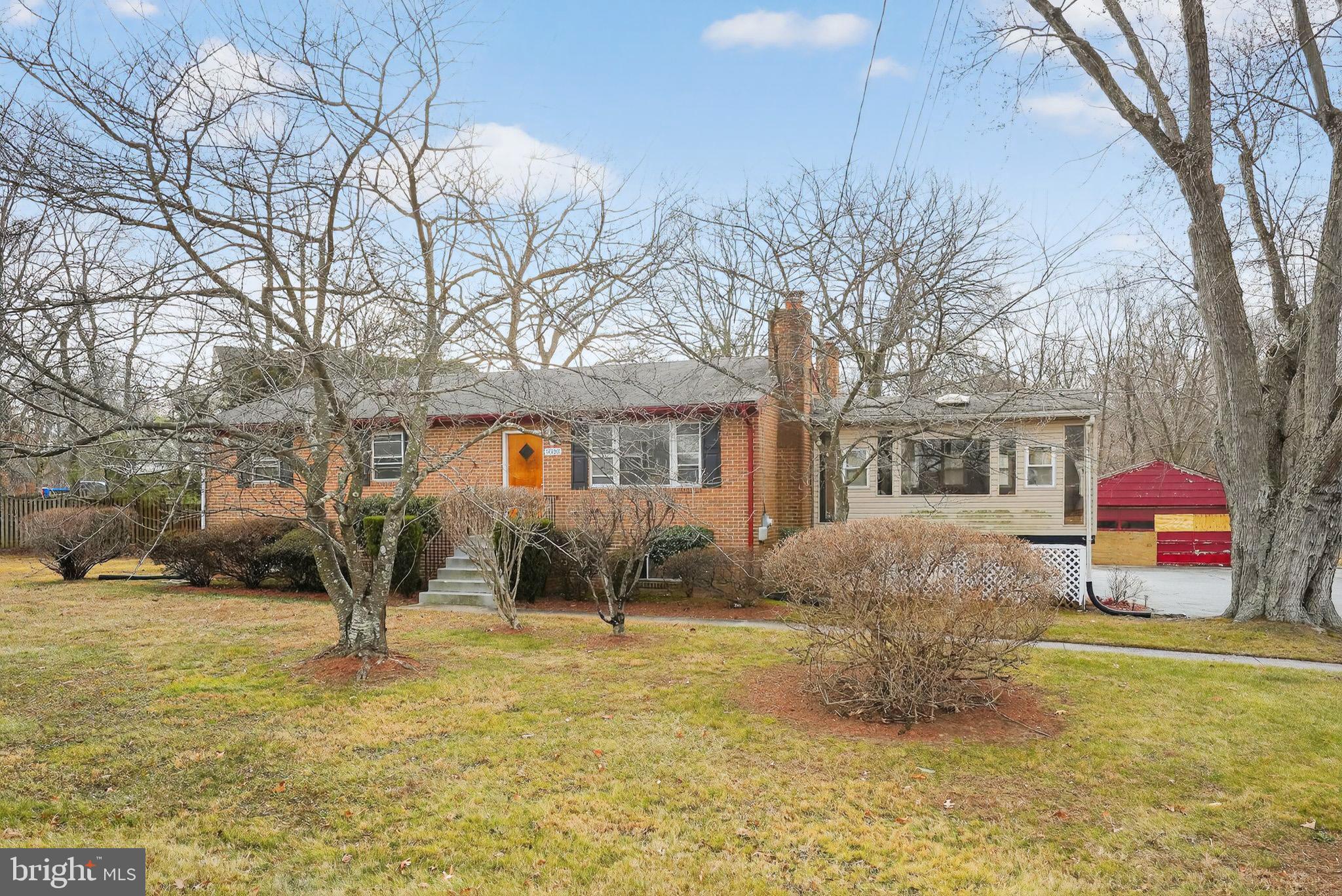 a front view of house with yard and trees around