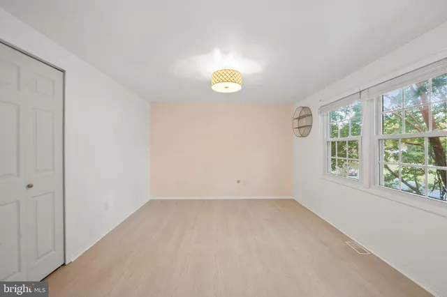 an empty room with a window and mirror