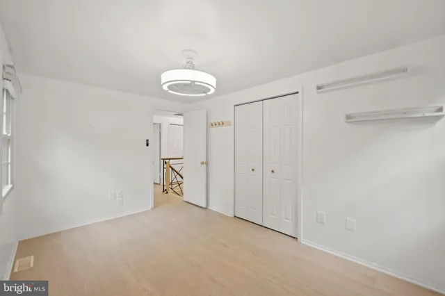 a bedroom with a bed and a dresser next to a window