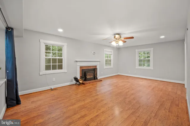 an empty room with windows and fireplace