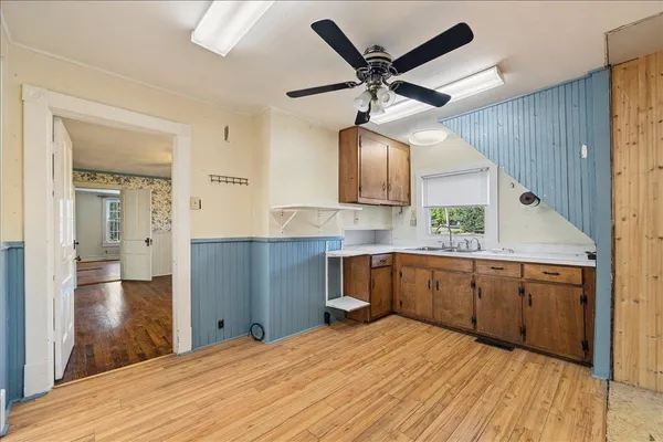 a kitchen with a refrigerator a sink and wooden floor
