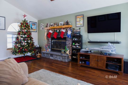 809 Charles Court Ridgecrest, CA 93555 - Photo 7 of 33 a living room with furniture a flat screen tv and a fireplace