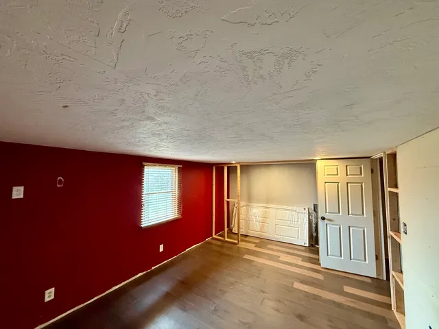 a view of empty room with wooden floor and windows