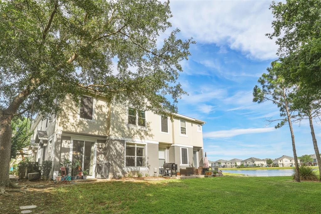 6458 South Goldenrod Road, Unit 29B Orlando, FL 32822 - Photo 32 of 40 a view of a white house next to a yard with big trees