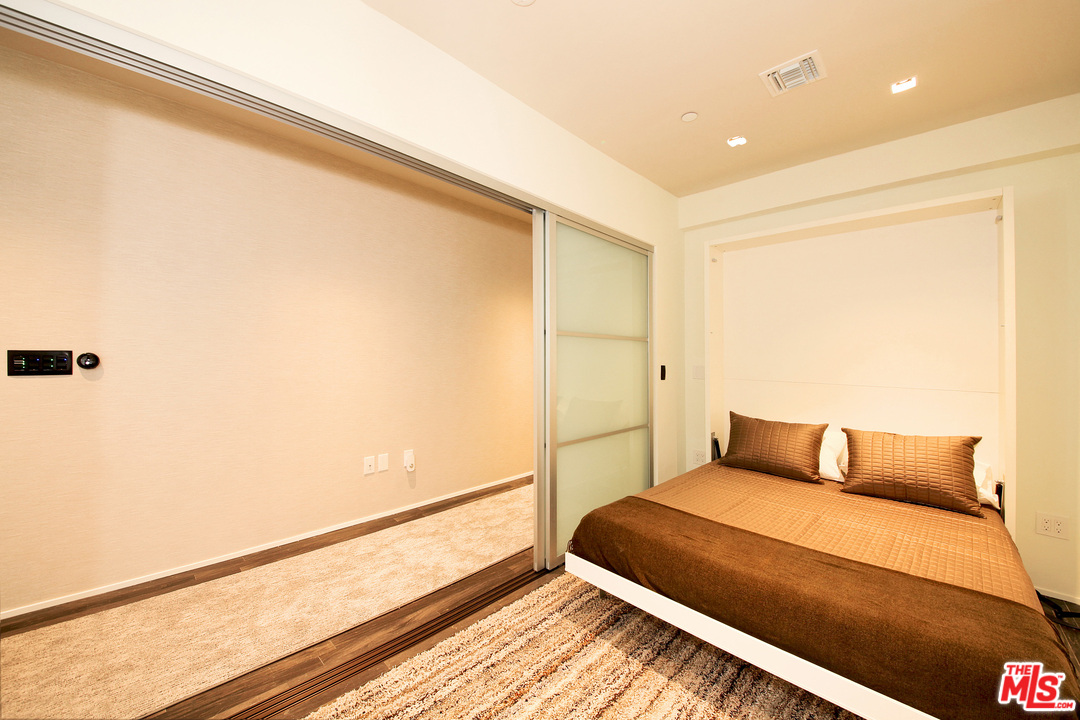 1645 Vine Street, Unit 908 Los Angeles, CA 90028 - Photo 26 of 52 a bedroom with a bed and wooden floor