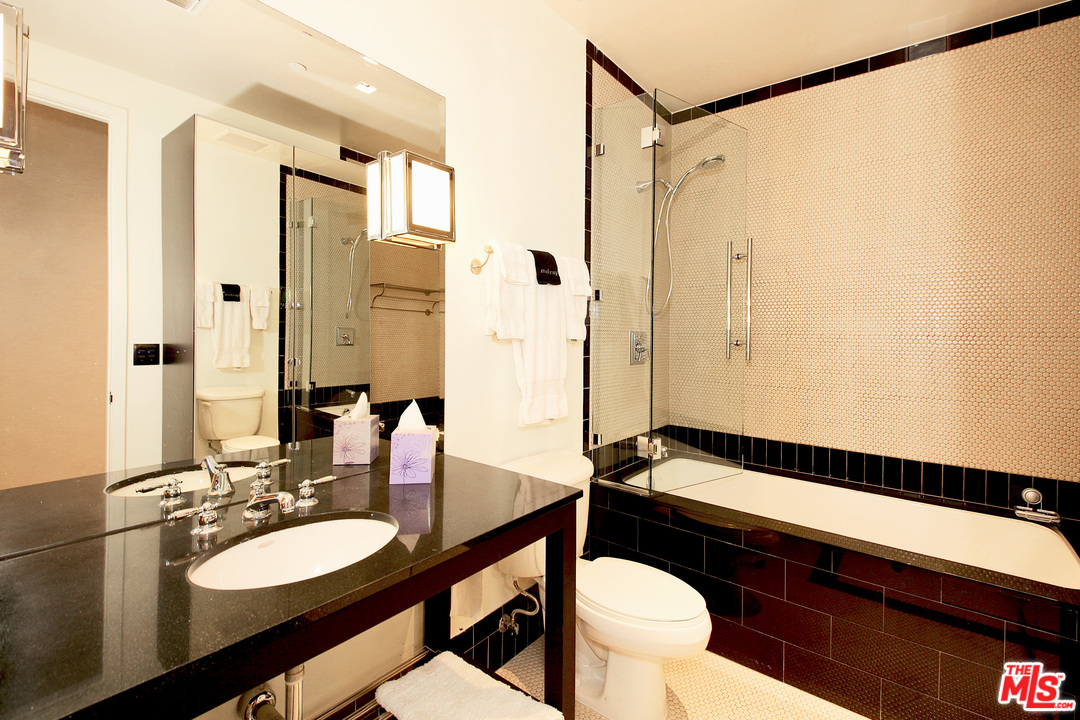 1645 Vine Street, Unit 908 Los Angeles, CA 90028 - Photo 29 of 52 a bathroom with a sink a toilet a mirror and shower