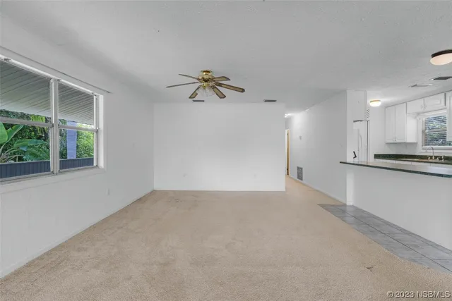 a view of a livingroom with a ceiling fan and window
