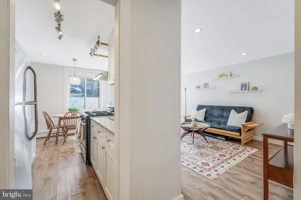 a living room with furniture a wooden floor and next to a window