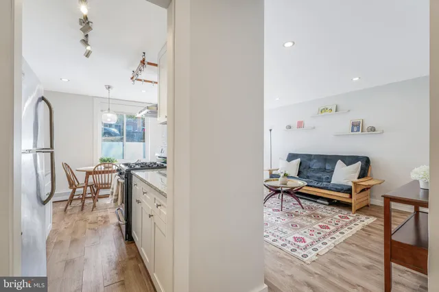 a living room with furniture a wooden floor and next to a window