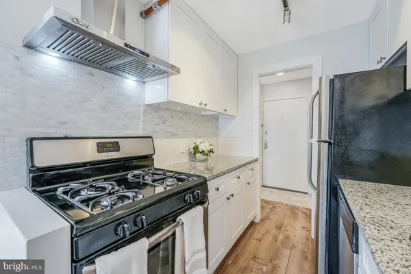 a kitchen with stainless steel appliances granite countertop a stove and a refrigerator
