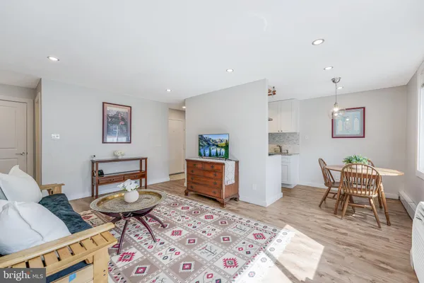 a living room with furniture and a dining table with rug