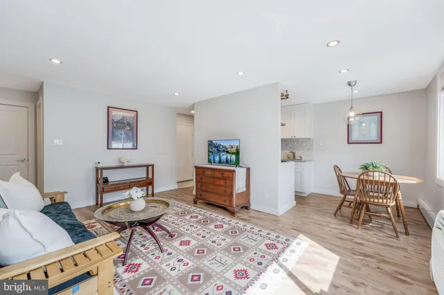 a living room with furniture and a dining table with rug