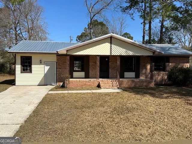 a view of a house with a yard and tree
