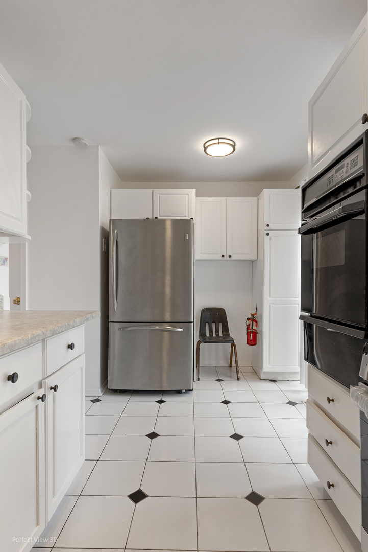 7539 North Ridge Boulevard, Unit 6 Chicago, IL 60645 - Photo 6 of 20 a kitchen with appliances a refrigerator and cabinets