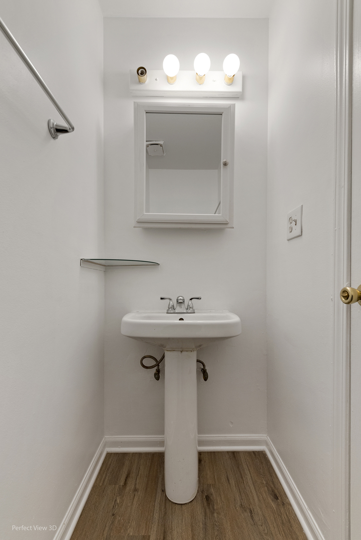 7539 North Ridge Boulevard, Unit 6 Chicago, IL 60645 - Photo 7 of 20 a bathroom with a sink toilet and mirror