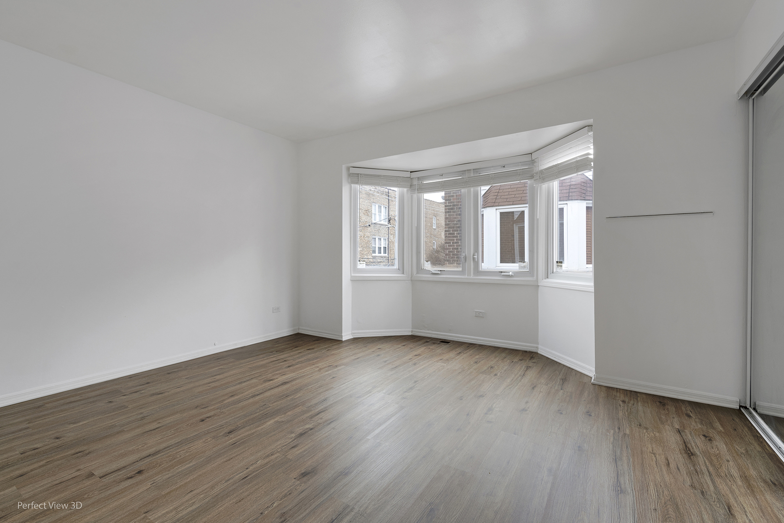 7539 North Ridge Boulevard, Unit 6 Chicago, IL 60645 - Photo 10 of 20 a view of an empty room with wooden floor and a window
