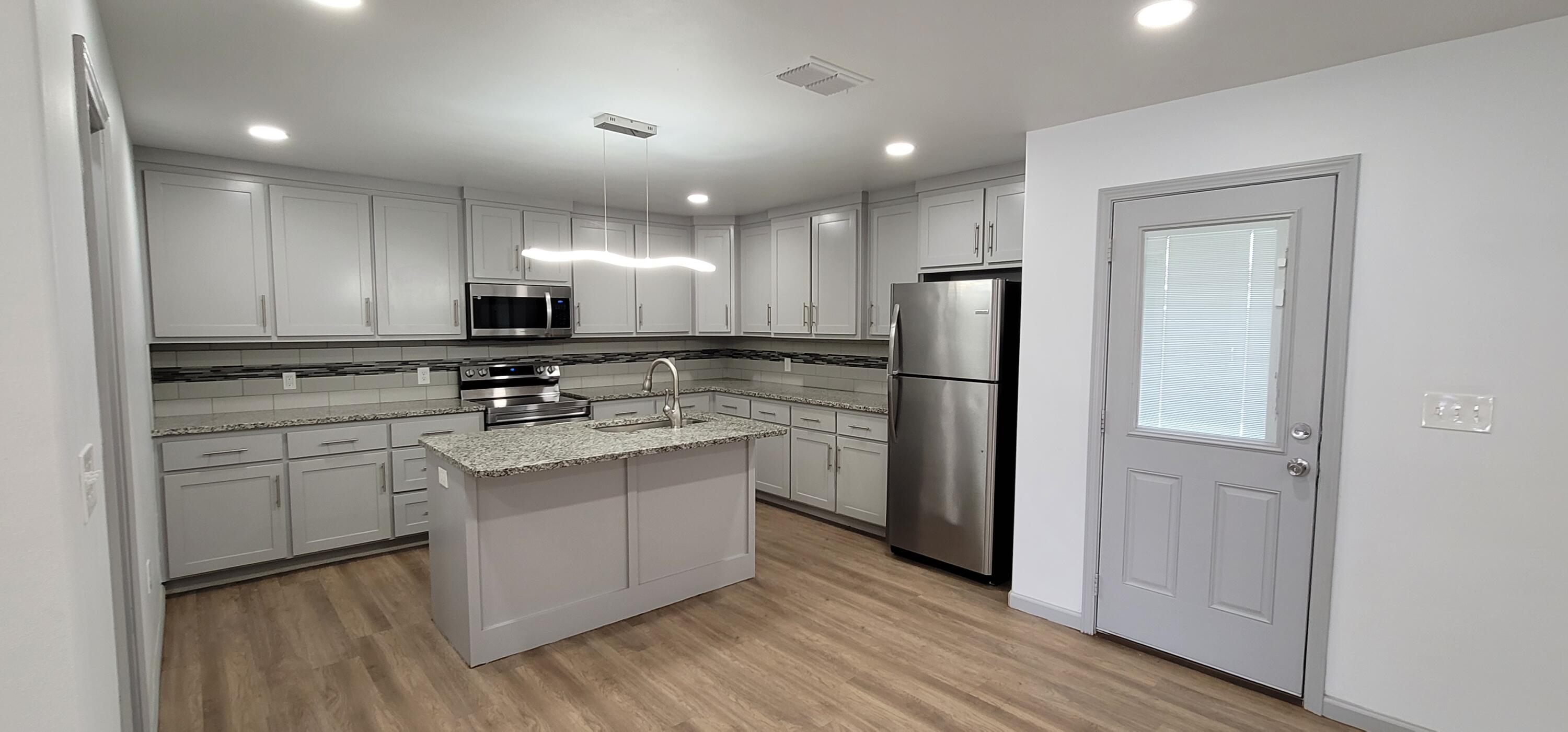 2110 88th Street Lubbock, TX 79423 - Photo 3 of 22 a kitchen with stainless steel appliances a refrigerator sink and microwave