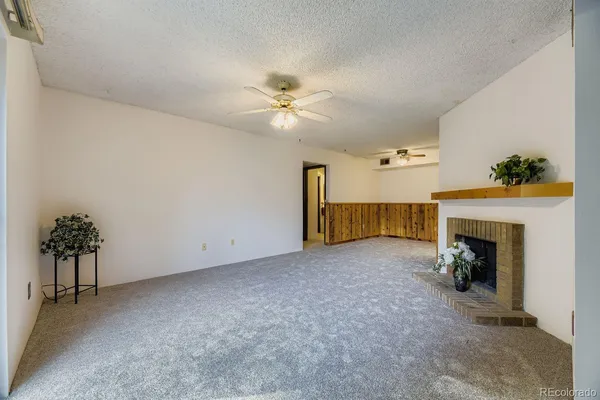 an empty room with fireplace and fan