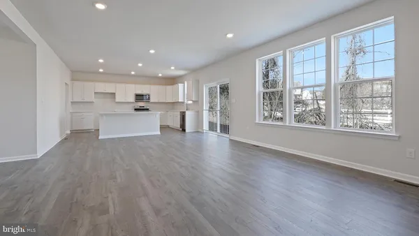 a kitchen with wooden floors white cabinets and stainless steel appliances