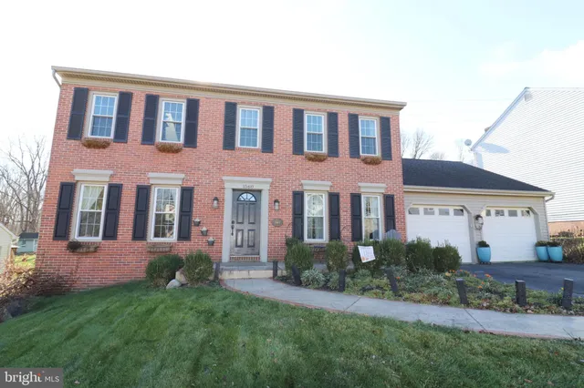 a view of a brick house with a yard and plants