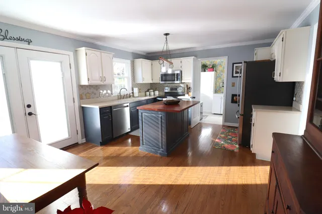a kitchen with stainless steel appliances a stove a microwave a sink and cabinets