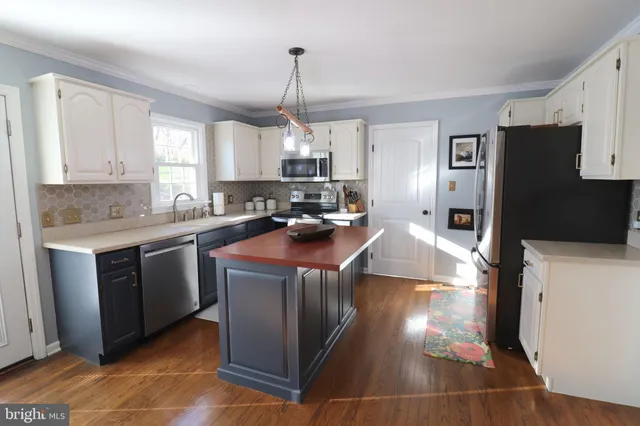 a kitchen with stainless steel appliances a stove a sink and a refrigerator