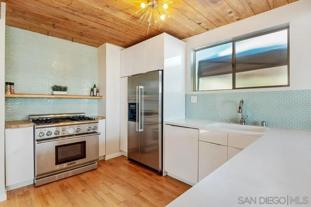 1238 Agate Street San Diego, CA 92109 - Photo 11 of 25 a kitchen with a stove and a refrigerator