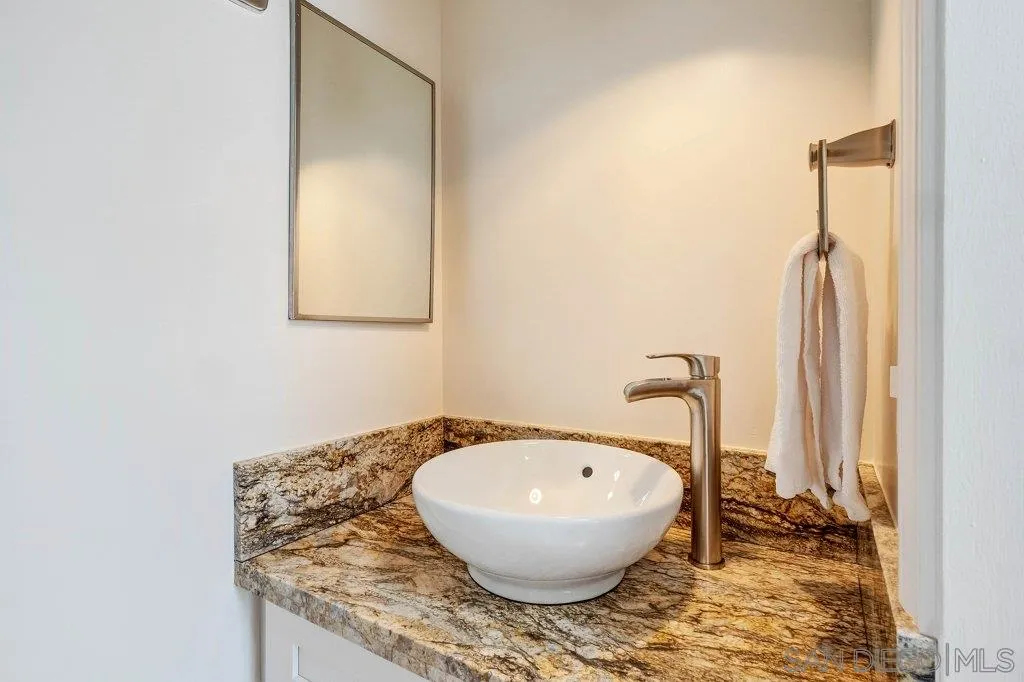 1238 Agate Street San Diego, CA 92109 - Photo 14 of 25 a bathroom with a granite countertop sink and a mirror