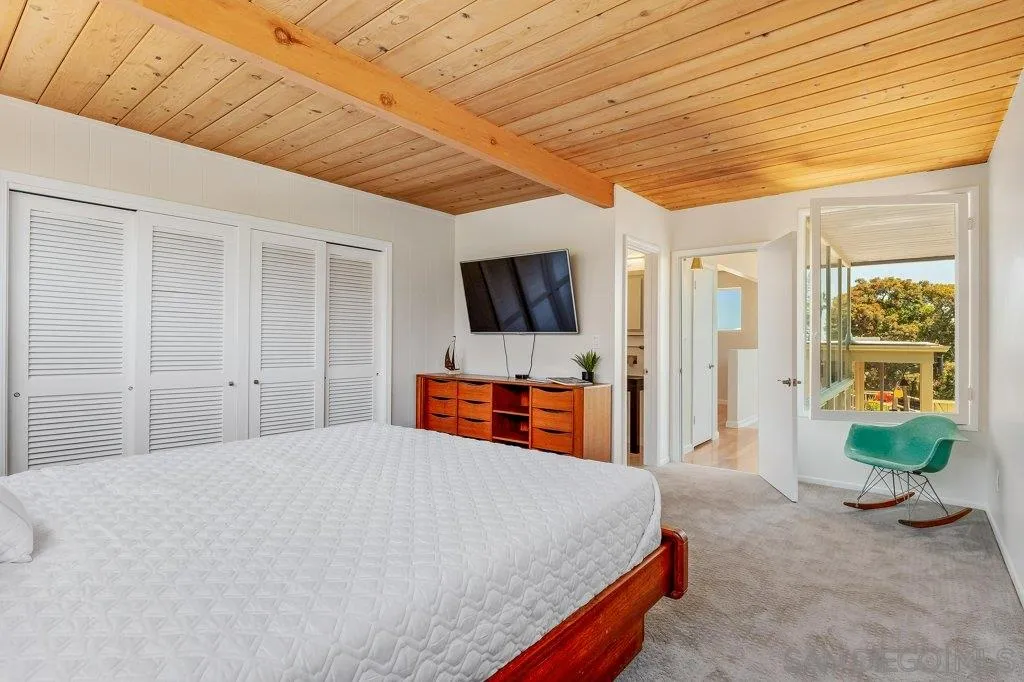 1238 Agate Street San Diego, CA 92109 - Photo 17 of 25 a spacious bedroom with a bed and a flat screen tv