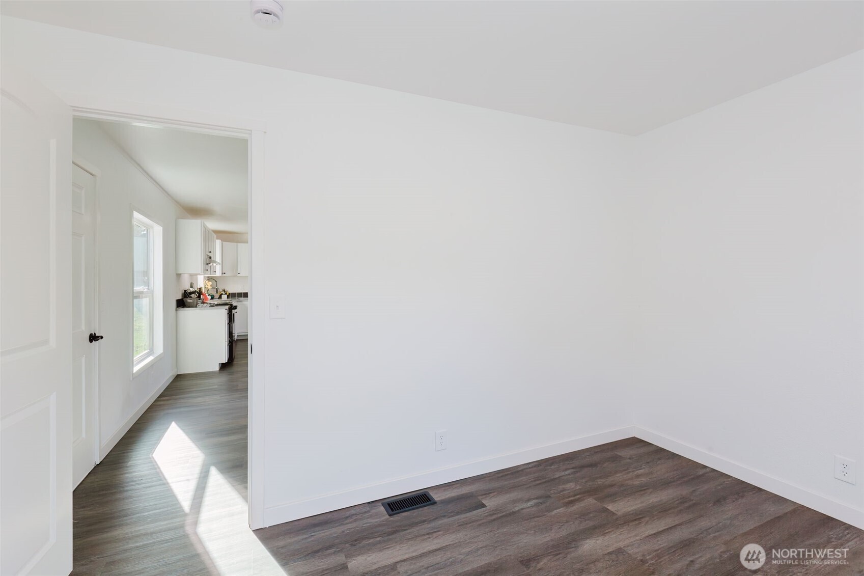 3371 Southeast Bielmeier Road, Unit 78 Port Orchard, WA 98367 - Photo 11 of 27 a view of a hallway with wooden floor and a bathroom