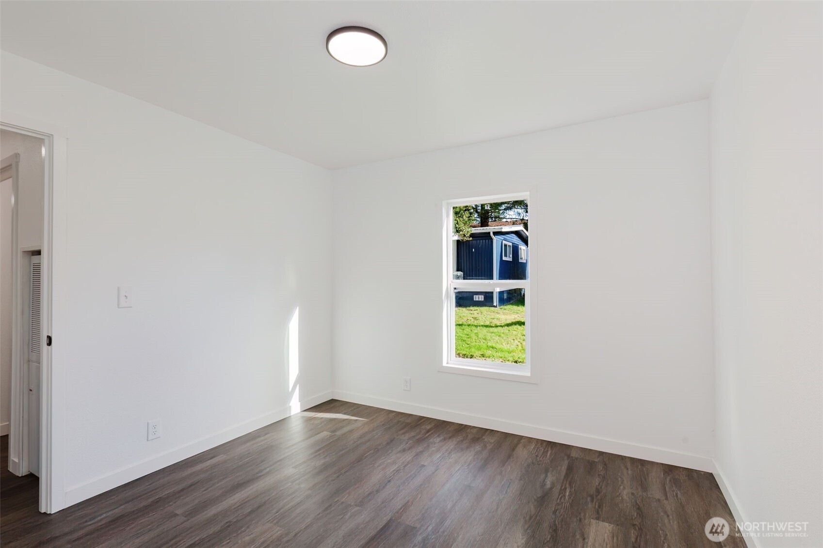 3371 Southeast Bielmeier Road, Unit 78 Port Orchard, WA 98367 - Photo 19 of 27 an empty room with wooden floor cabinet and windows