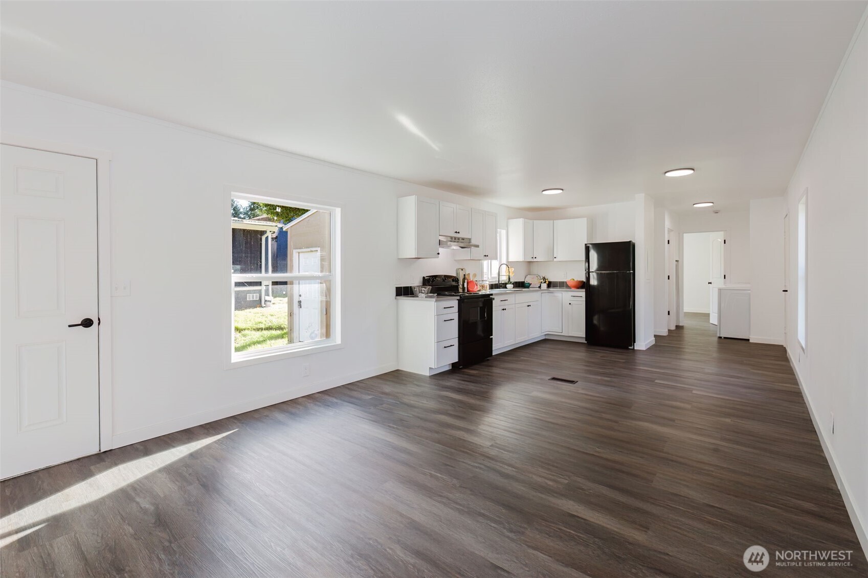 3371 Southeast Bielmeier Road, Unit 78 Port Orchard, WA 98367 - Photo 5 of 27 a view of a electric appliances in kitchen and empty room with wooden floor and windows