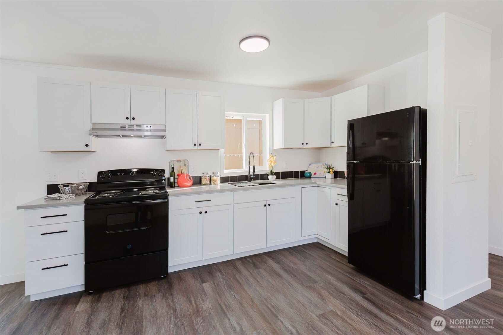 3371 Southeast Bielmeier Road, Unit 78 Port Orchard, WA 98367 - Photo 6 of 27 a kitchen with a refrigerator stove and white cabinets