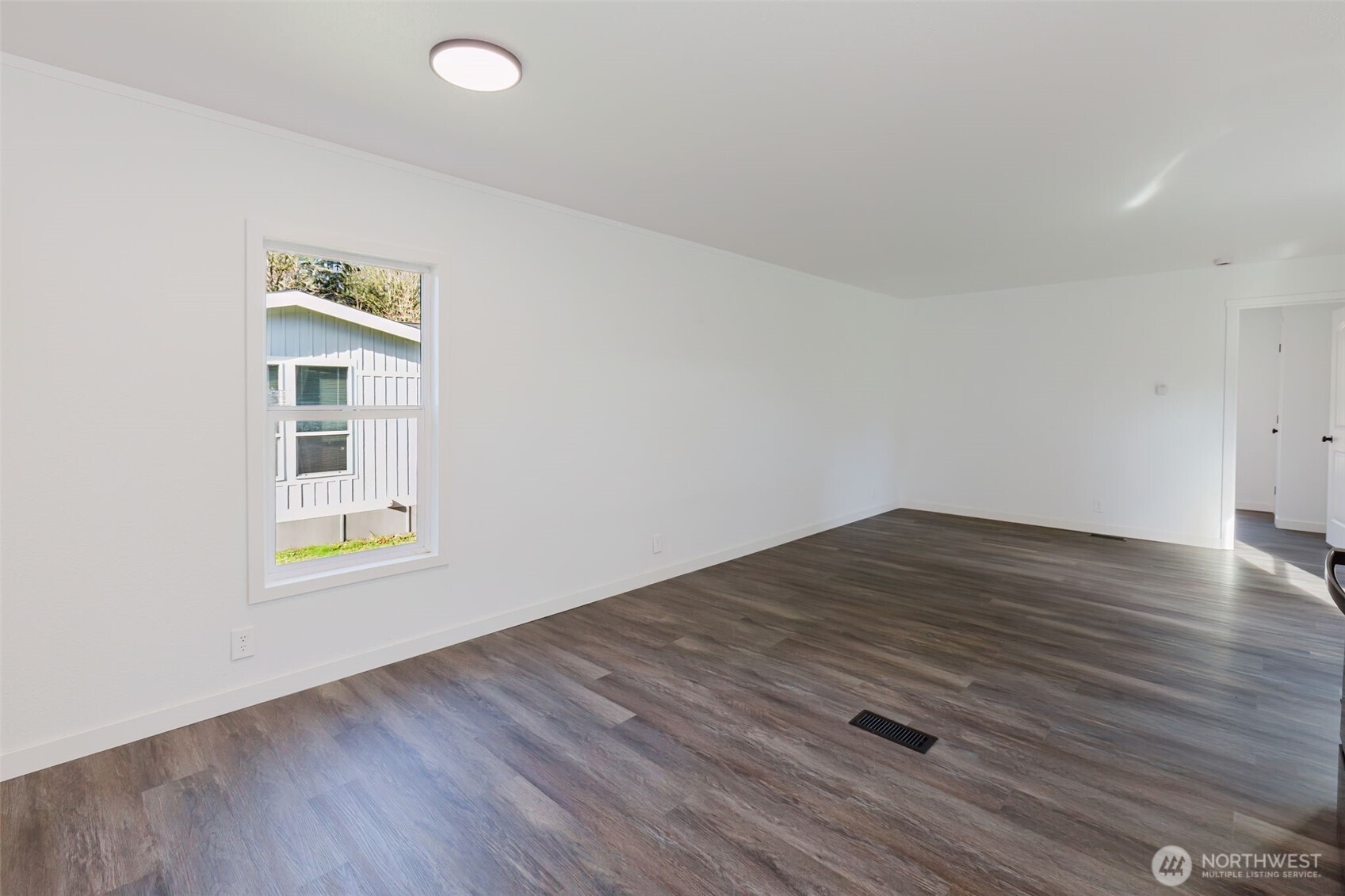 3371 Southeast Bielmeier Road, Unit 78 Port Orchard, WA 98367 - Photo 8 of 27 an empty room with wooden floor and windows