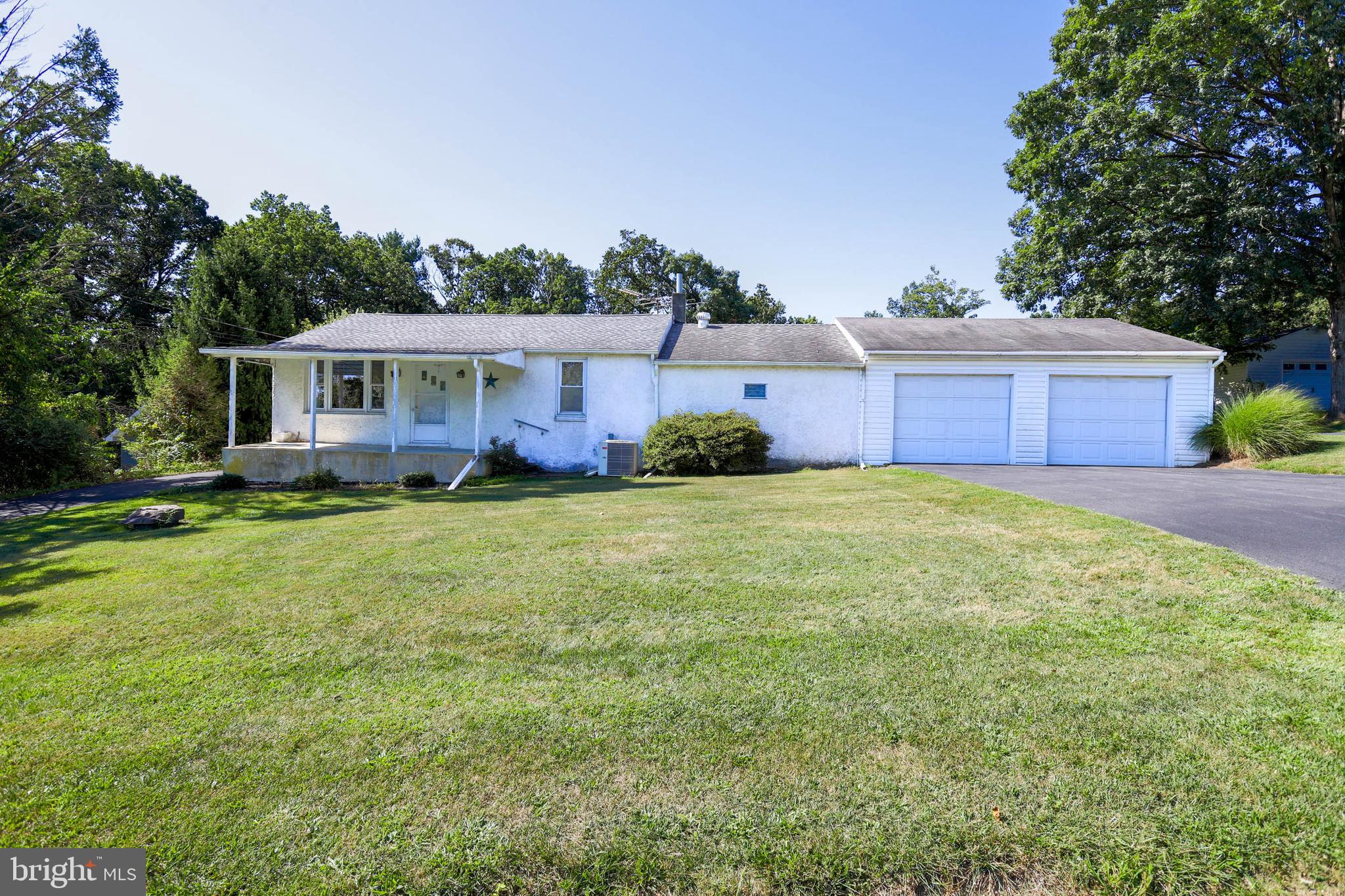 a front view of house with yard and trees in the background