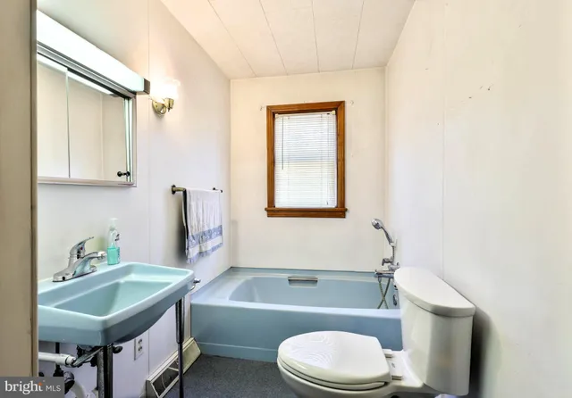 a bathroom with a sink toilet vanity and bathtub