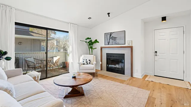 a living room with furniture a fireplace and a table
