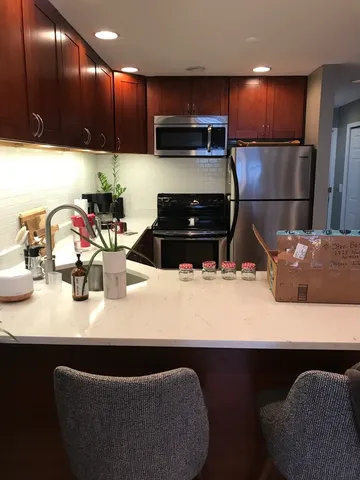 a kitchen with kitchen island a sink stainless steel appliances and cabinets