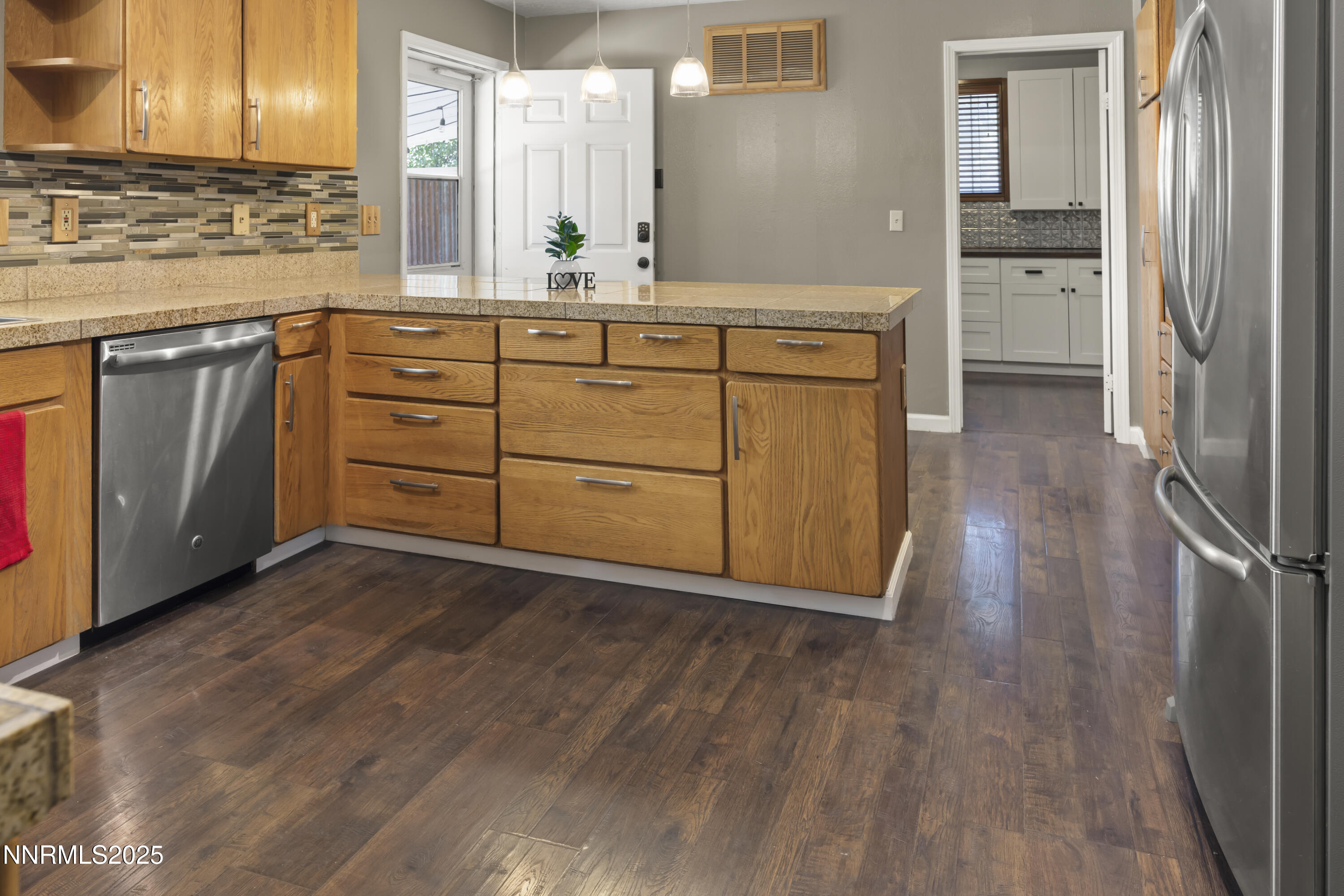 1165 Farm Lane Fernley, NV 89408 - Photo 11 of 38 a kitchen with stainless steel appliances granite countertop a stove a sink and a refrigerator with wooden floors