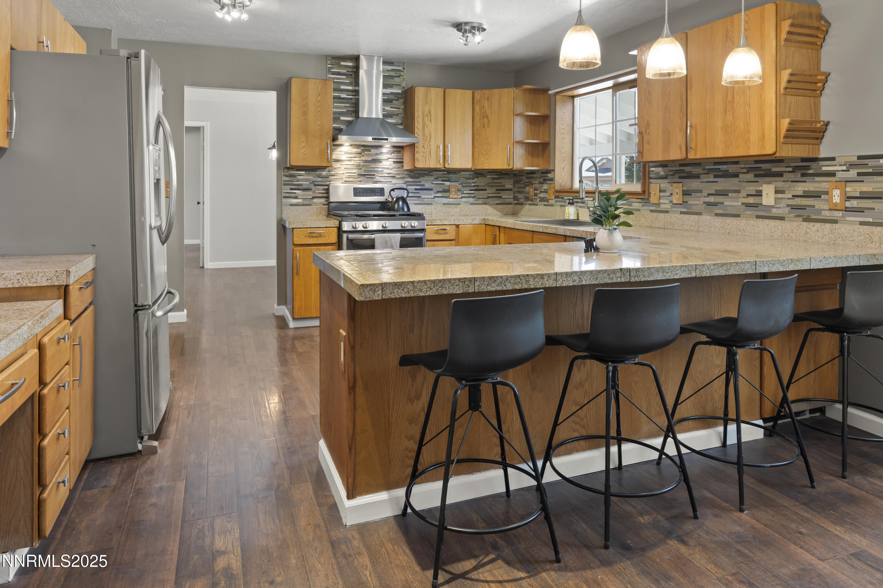 1165 Farm Lane Fernley, NV 89408 - Photo 12 of 38 a kitchen with stainless steel appliances granite countertop table chairs sink and wooden floor