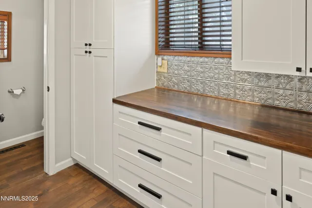 a view of kitchen with granite countertop cabinets and window