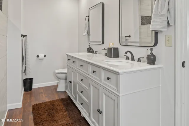 a bathroom with a double vanity sink mirror and toilet