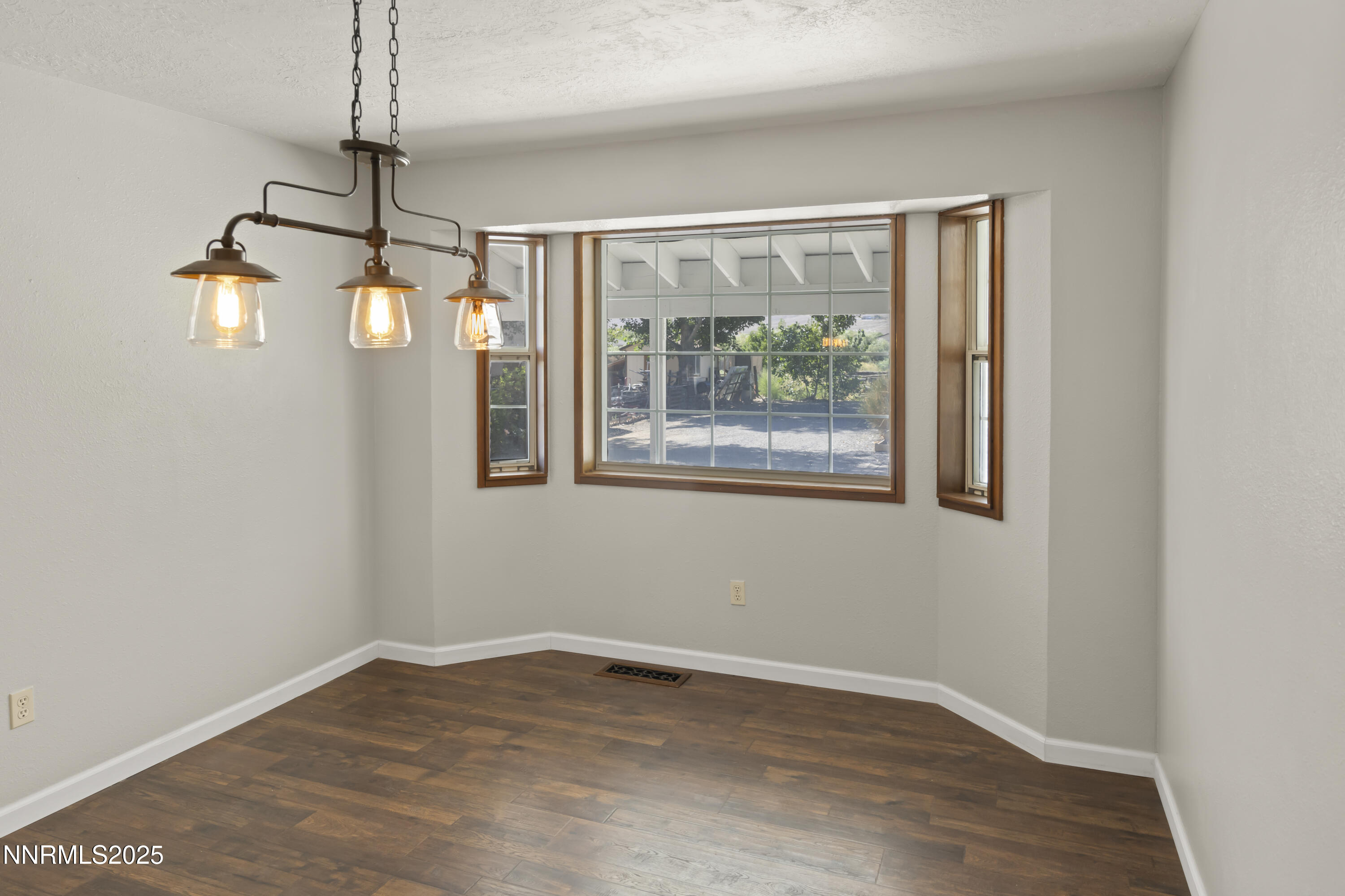 1165 Farm Lane Fernley, NV 89408 - Photo 8 of 38 a view of empty room with wooden floor and fan